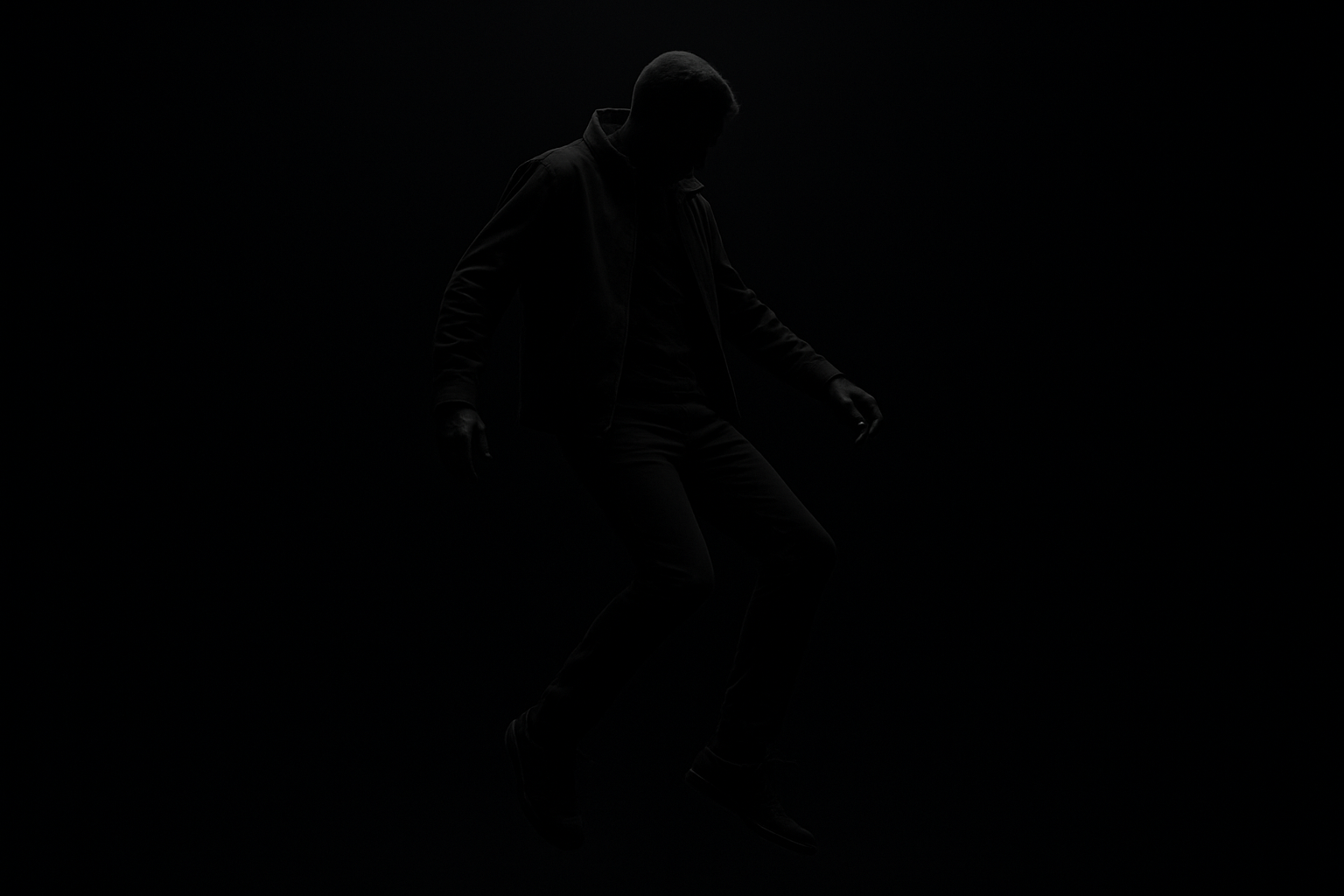 floating man in black clothes, black background
